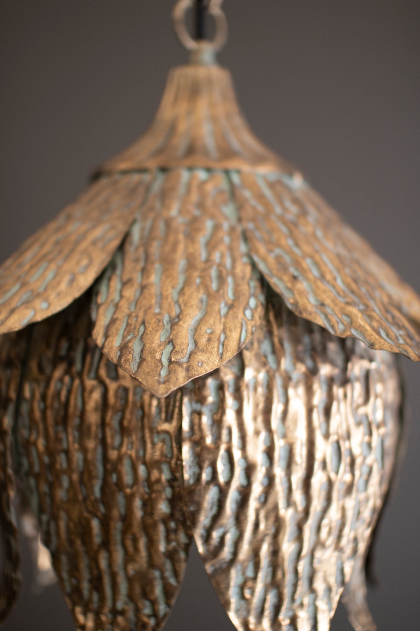 Antique Brass Tulip Pendant Light with textured, layered petals in warm tones, showcasing a sculptural design.