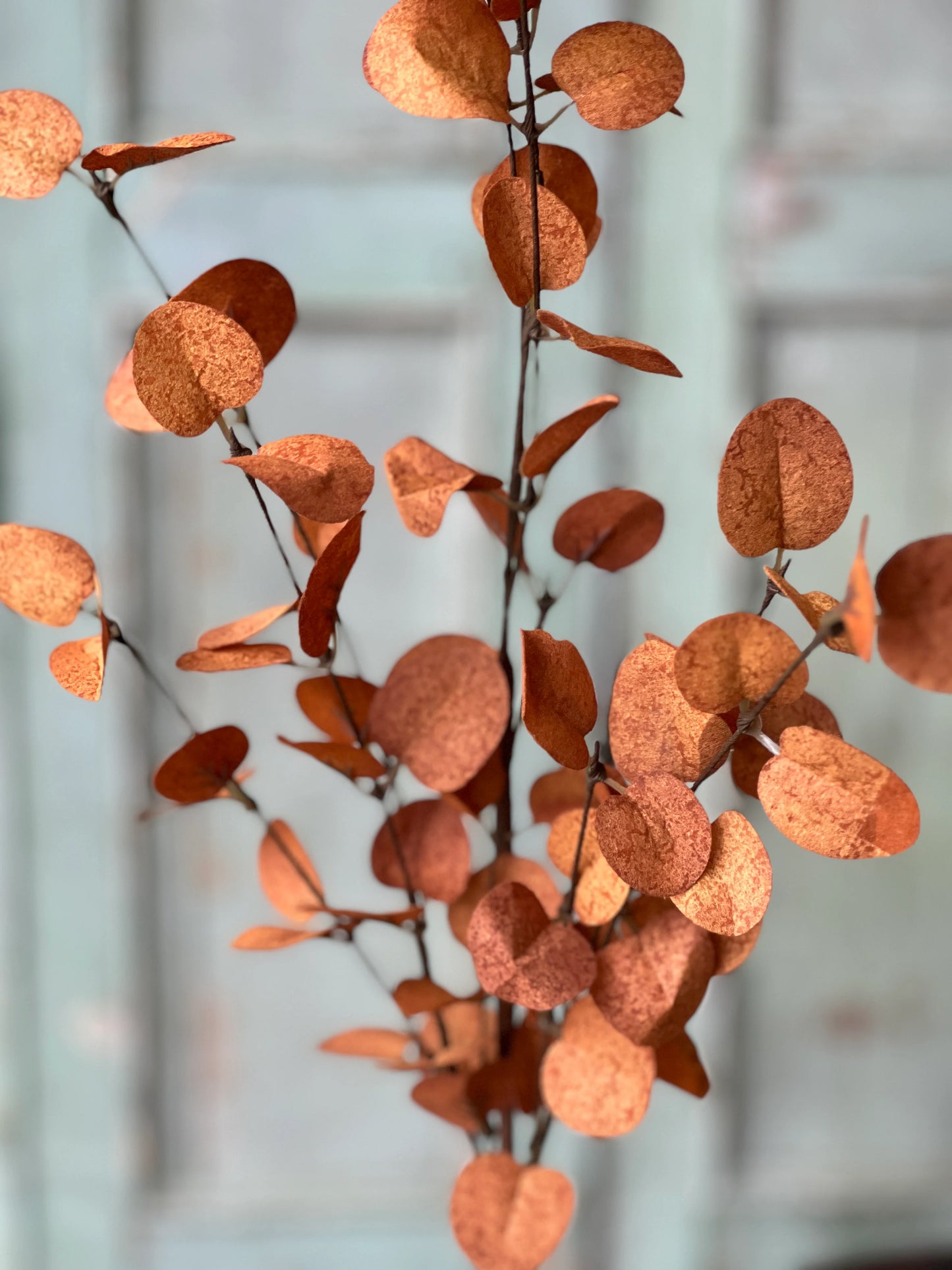 up close of faux floral stem in bright orange red for fall