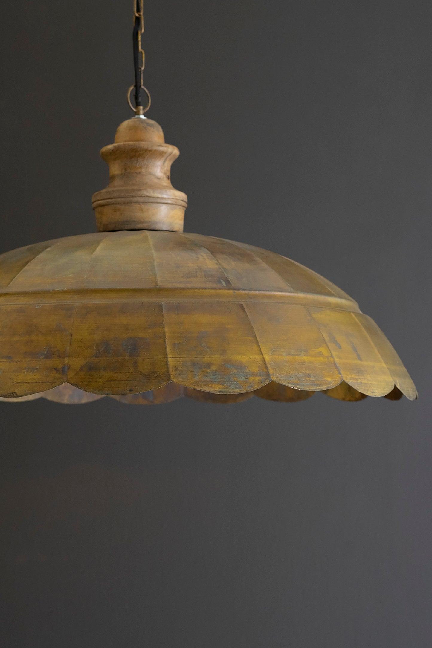 Antique Brass Dome Pendant Light with Wood Detail, showcasing a scalloped dome and wooden accent against a dark background.