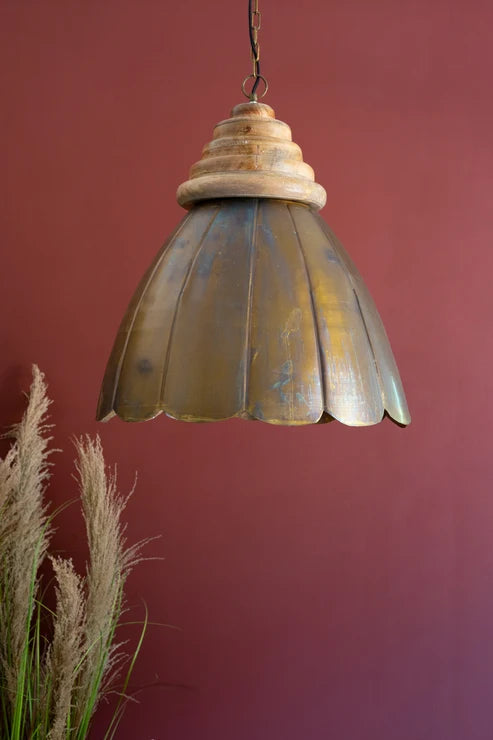 Vintage-style pendant light with a textured shade against a red wall.