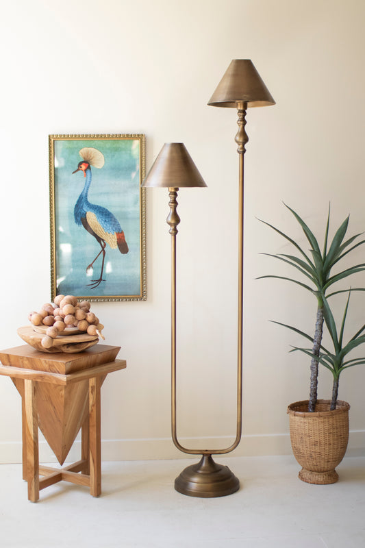 Antique Gold Double Floor Lamp with Metal Shades beside a vibrant bird painting and greenery in a cozy setting.