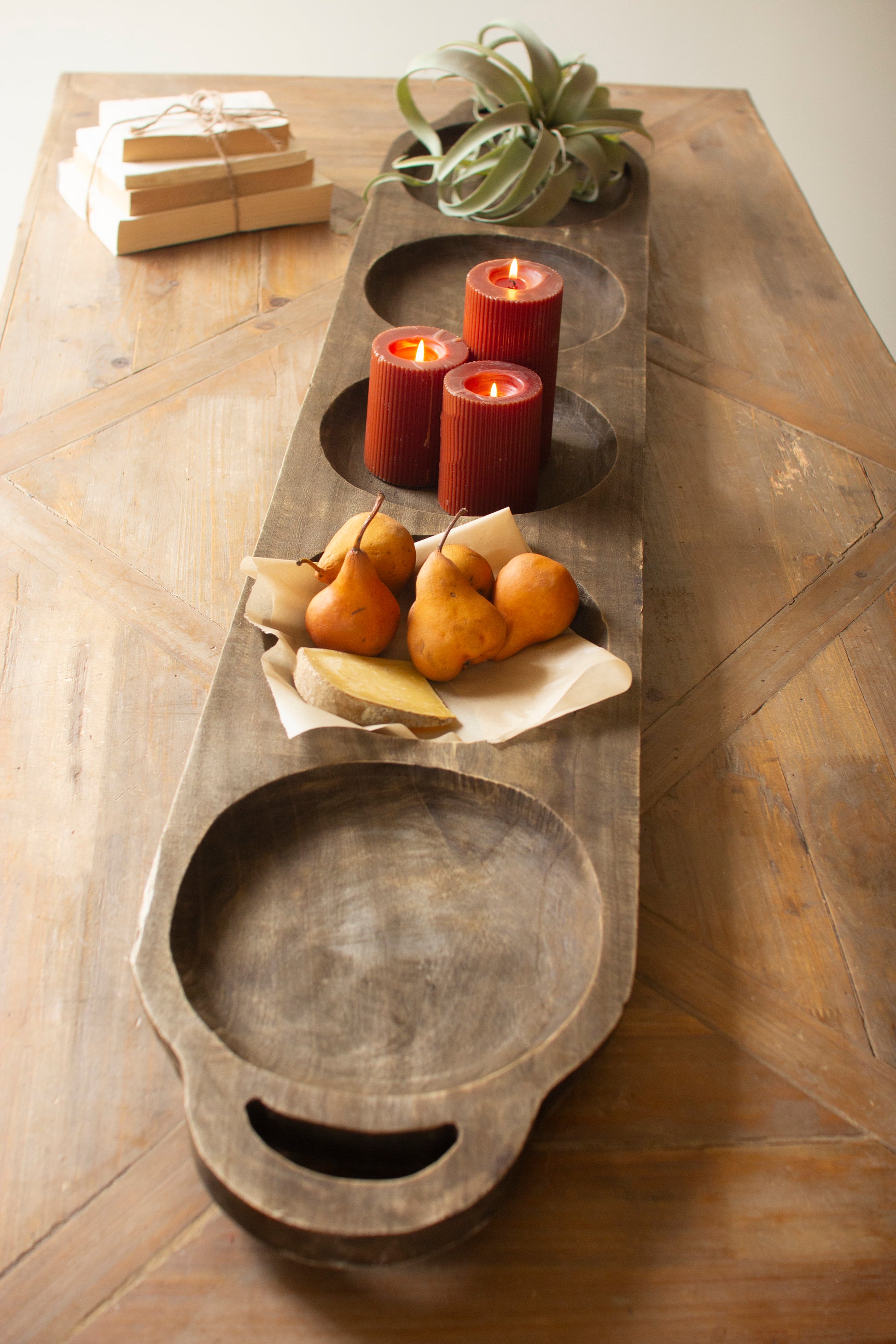 Wooden tray with pears and candles on a wooden surface