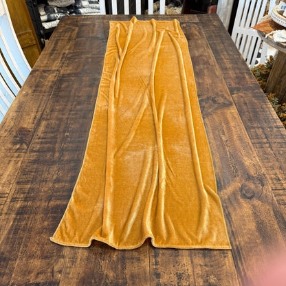 A mustard yellow velvet table runner