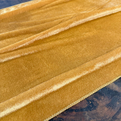 A close-up of draped gold table runner for fall