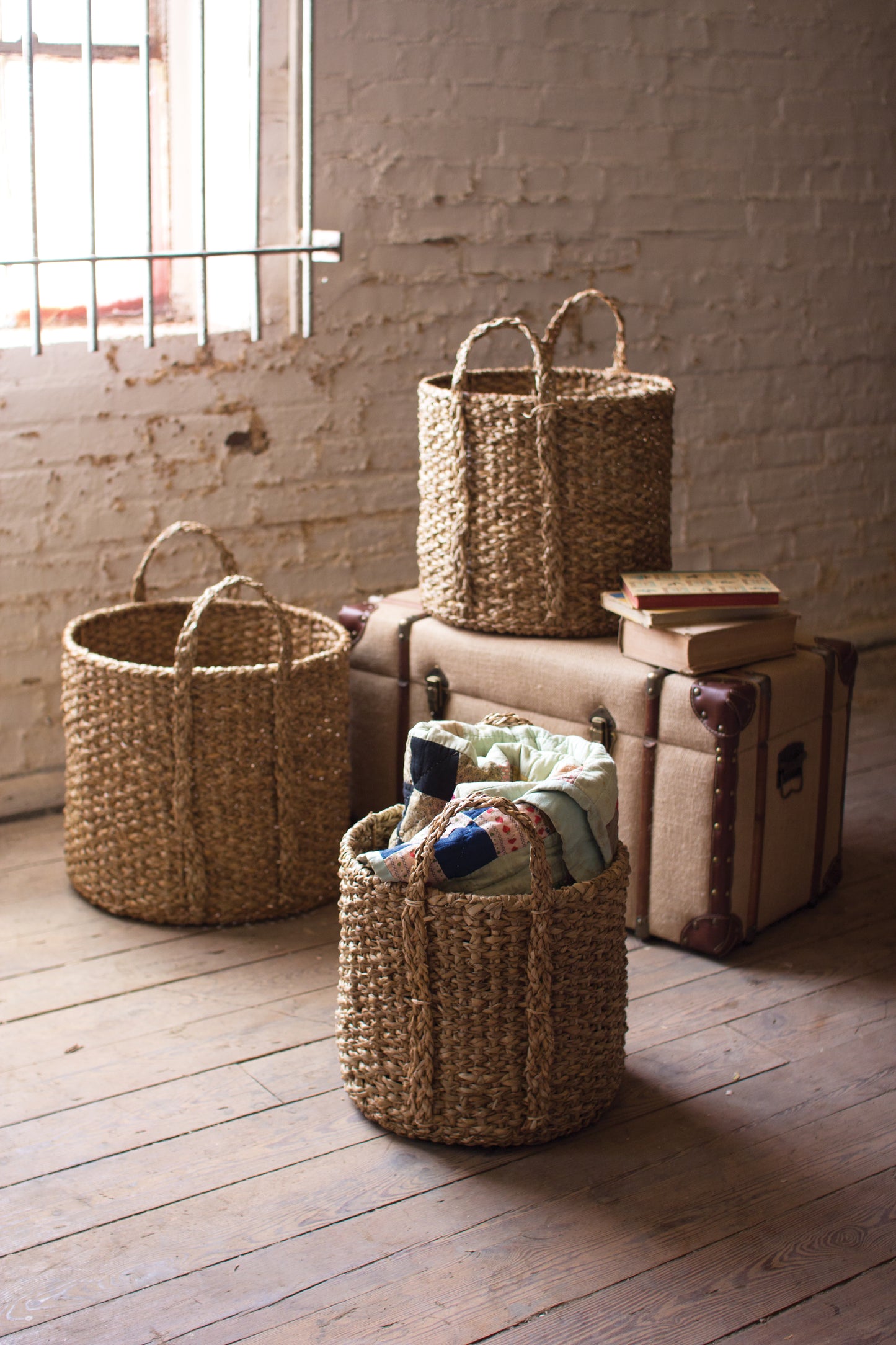 Set of three braided seagrass storage baskets with handles