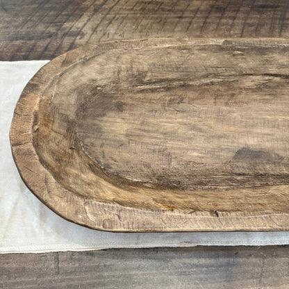 Wood oval bowl on wood table close up