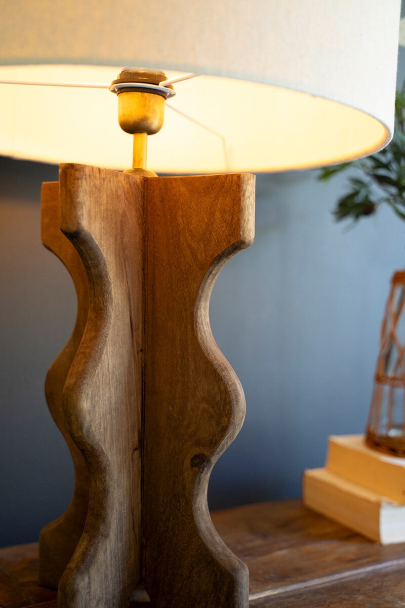 Wavy Mango Wood Table Lamp with white shade on a wooden table