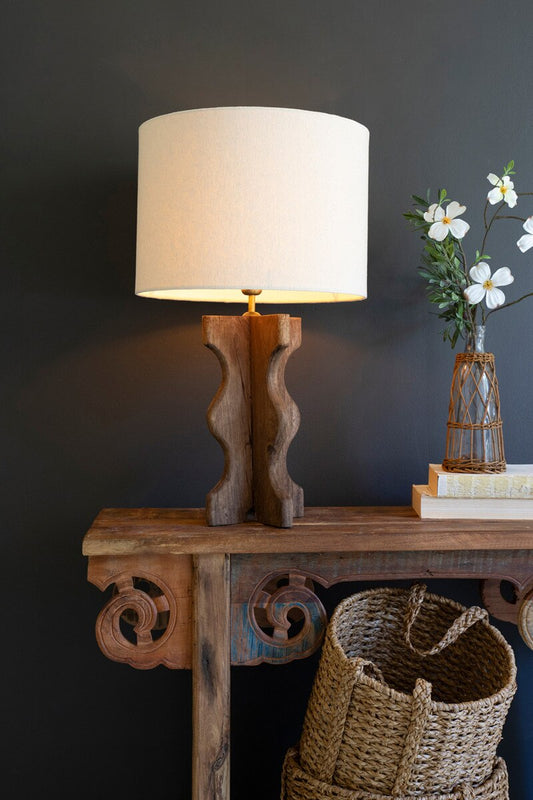 Wavy Mango Wood Table Lamp with Fabric Shade on table against a dark wall
