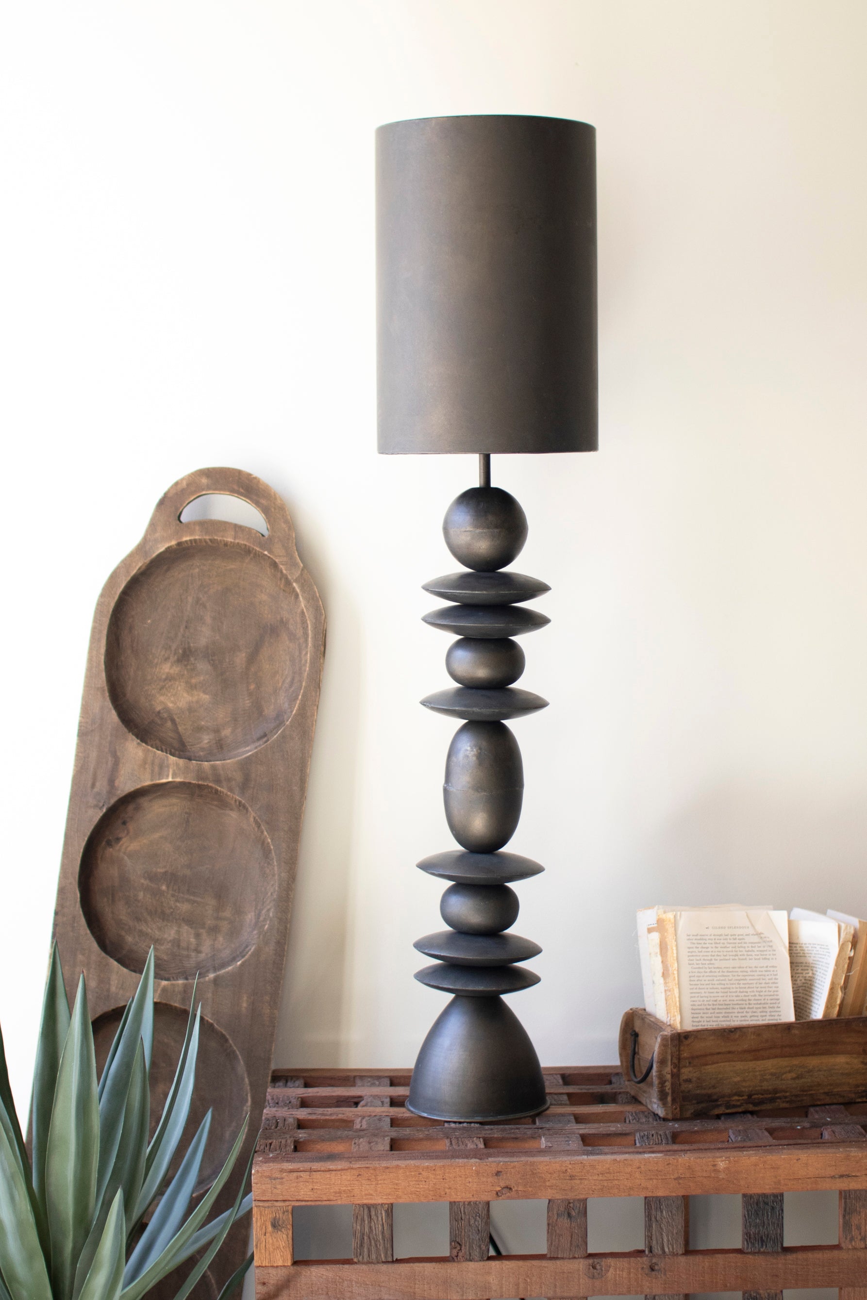 Antique Bronze Table Lamp with sculptural stacked base, simple shade, and rustic wooden accents, perfect for cozy spaces.