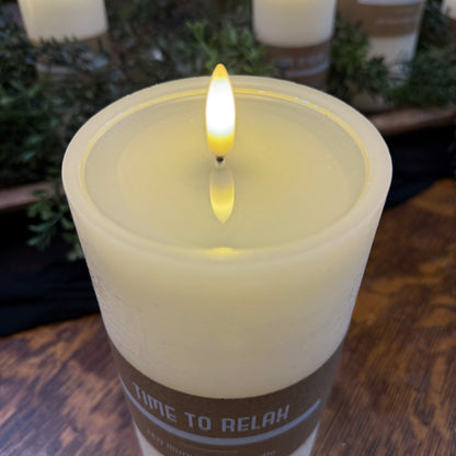 Battery pillar candle- rustic home decor - candlelight on a wooden surface with greenery in the background