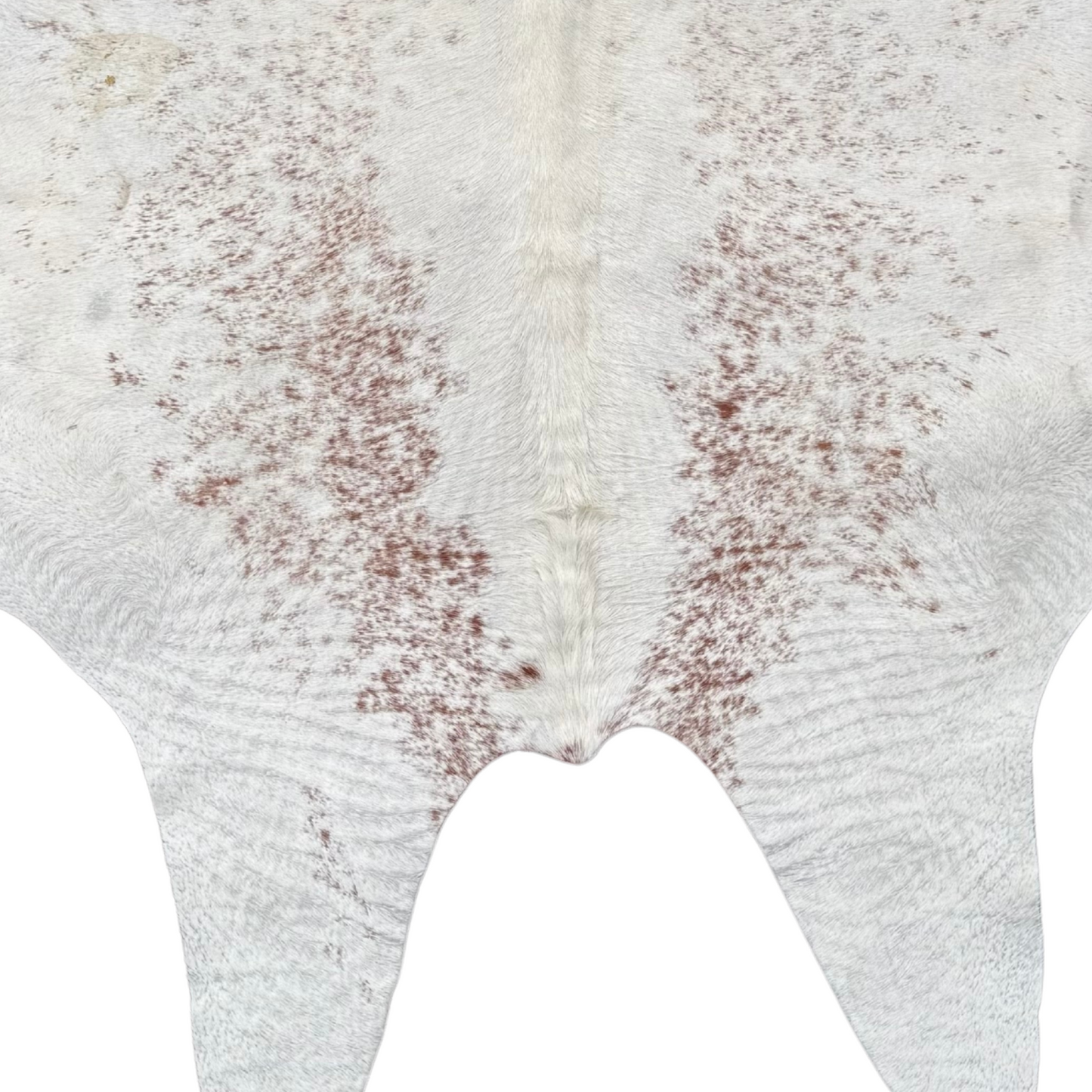 Close-up of a cowhide rug with a white base and brown patches