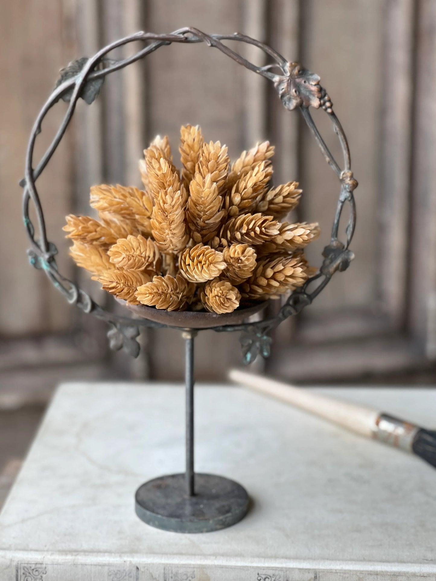 fall beige hops  a fall floral sphere sitting on metal candle holder