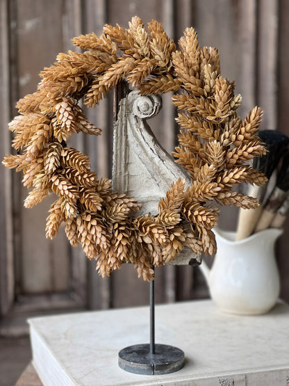 A beige hops candle ring with a grapevine base and textured elements, displayed on a table.