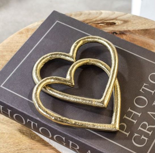 Gold heart-shaped objects on a book with a wooden surface