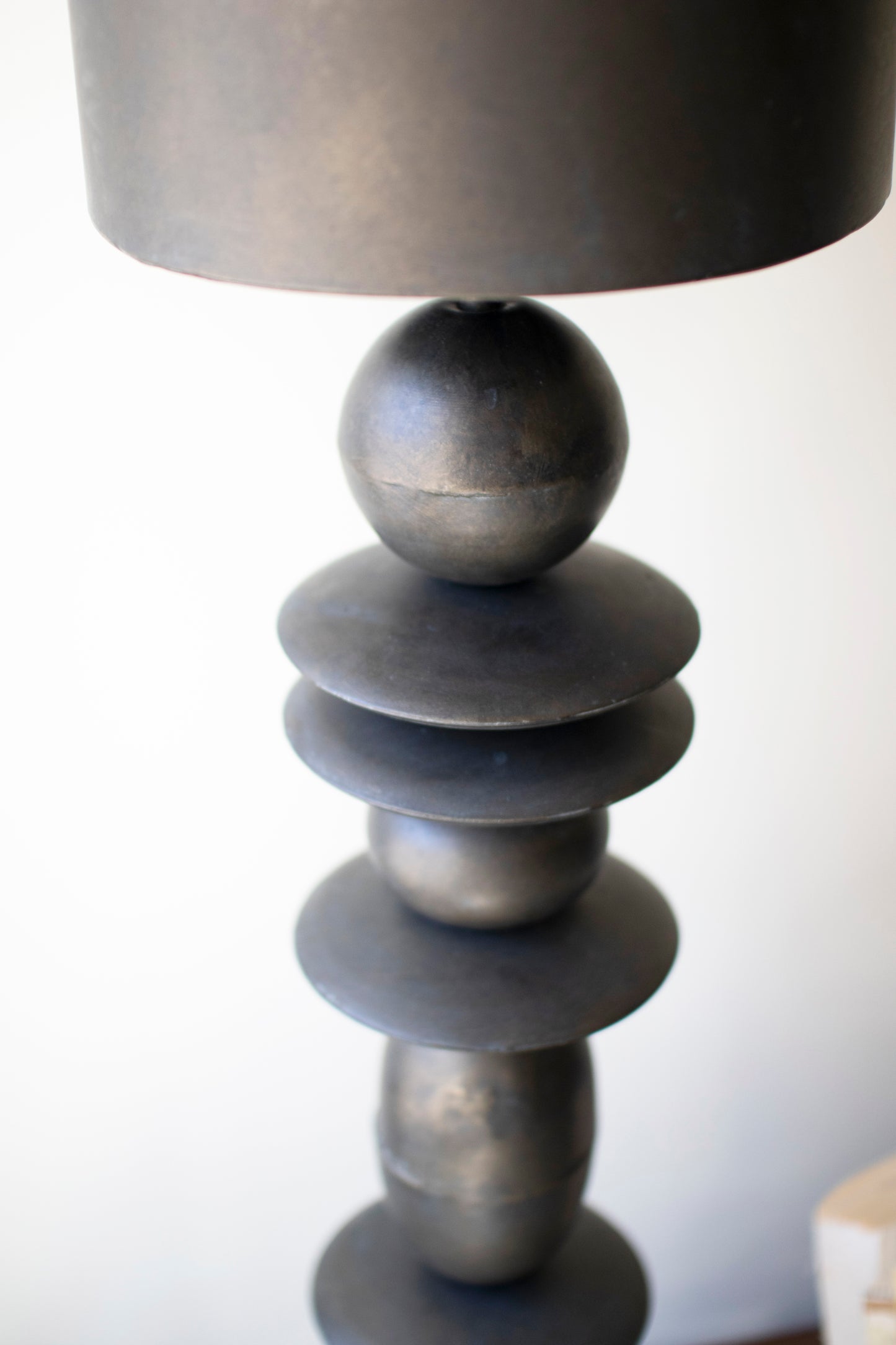 Antique Bronze Table Lamp with a sculptural stacked base and simple shade, creating a warm glow.
