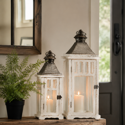 rustic white lanterns with cream candles on table by fern - rustic home decor