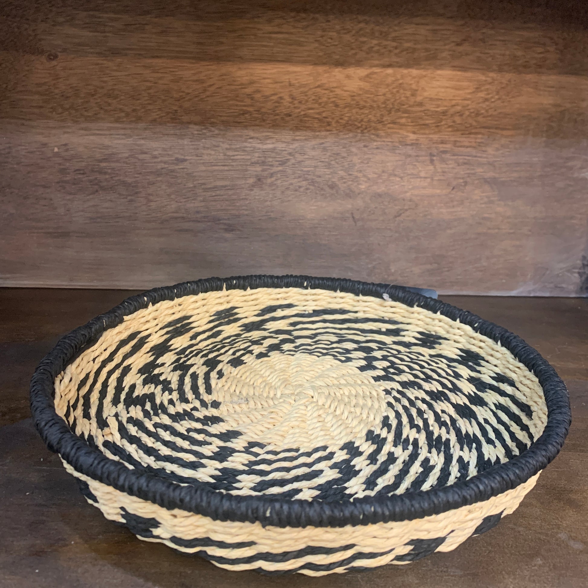 natural and black seagrass basket on shelf