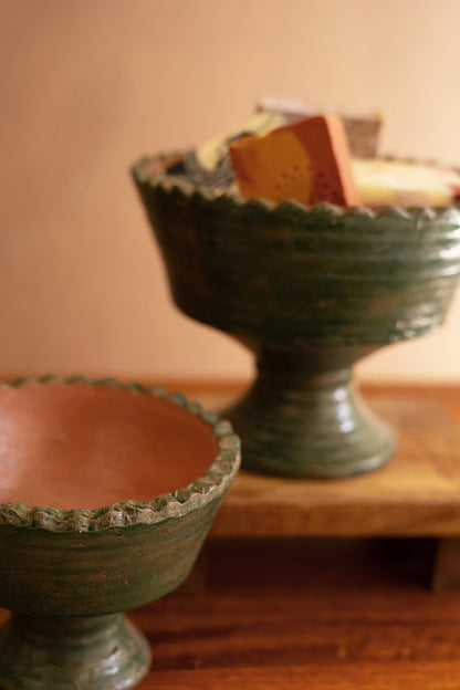 Two ceramic bowls with textured rims on a wooden surface.