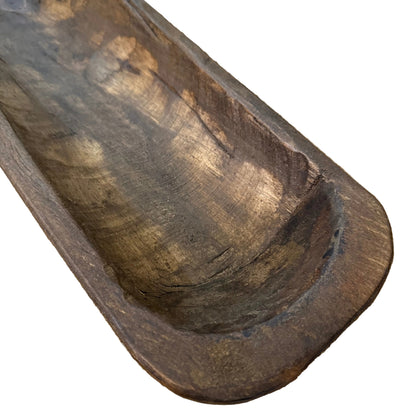 A rustic dark brown wooden bowl with a carved bowl shape.